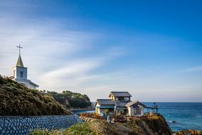 panorama of a church and a house on a hill by the sea