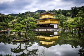 temple is reflected in the water in the japanese garden