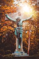 crucifix in sunlight in a cemetery in autumn