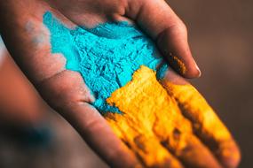 Blue, yellow and orange pain on the hand, on the Holi