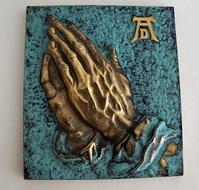hands in prayer as a bronze sculpture