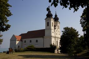 Beautiful church, among the colorful plants, on the shore in Hungary