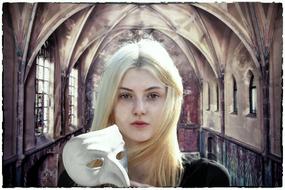 Gothic portrait of the beautiful, blonde girl, with the white mask, in the building