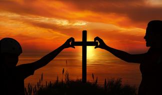 picture of hands of people on cross against the background of a fiery sunset