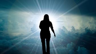 silhouette of a girl on a background of solar glow in the sky