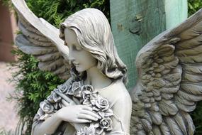 mourning Angel with flowers, cemetery Statue