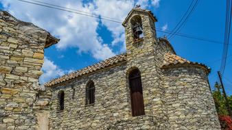 Landscape of the beautiful church in Kato Lefkara, among the plants, at blue sky with white clouds on Cyprus, Greece