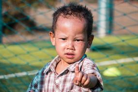 small asian child boy pointing finger straight