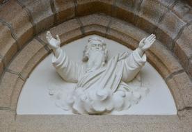 Of God in clouds, sculpture on facade, france, brittany