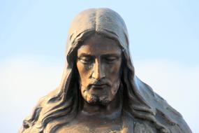 statue of Jesus on a cemetery on beautiful sky background