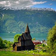 aged Stave Church on side of scenic Fjord at Mountain, norway, urnes