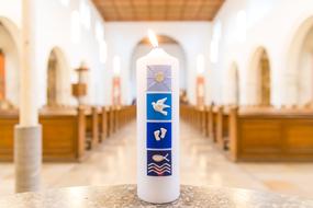 photo of a white burning candle in a church