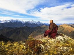 Monk of Theravada Buddhism, on the colorful and beautiful mountains, looking on the snowy Himalayas