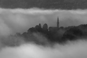 black and white panoramic photo of a church in the fog in Dolenjska, Slovenia