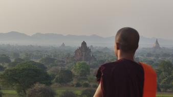 monk is looking at a Buddhist temple complex