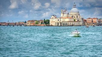 motor boat speeding on blue water in front of city, italy, Venice