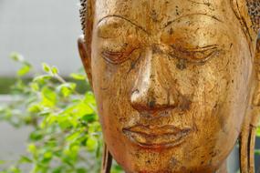 golden face of Buddha statue close up