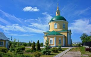 photo of green landscape in front of the orthodox church