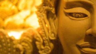 Buddha statue head on the background of burning candles