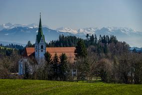 Beautiful landscape with the church, among the green trees on the mountains, in summer