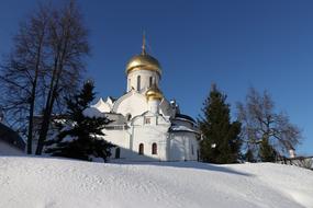white church with golden domes in a winter landscape