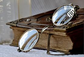 glasses on old book close up