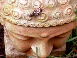 Snail Reptile on stone buddha statue