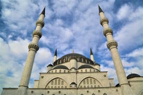 Beautiful mosque with minaret at blue sky with white clouds