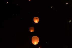 Beautiful, orange and yellow sky lanterns in the black sky, at night