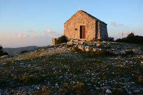 small stone church on a hill at sunset