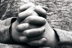 monochrome photo of hands folded in the lock