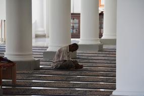 Praying person on steps of Mosque