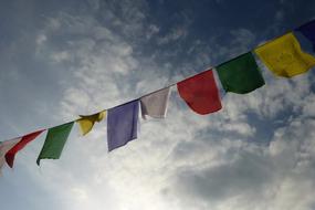 multicolored prayer flags against a cloudy sky in Nepal