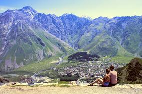 young couple rest at Kazbek Mountain, georgia, stepantsminda