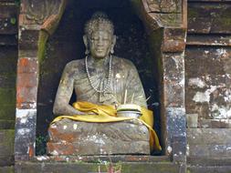 buddha statue at temple wall in bali island, indonesia