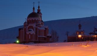 church with domes among the snowy landscape at night