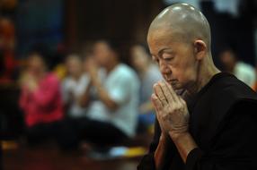 buddhist in prayer close-up on blurred background