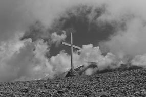 black and white photo of a wooden cross on a hill