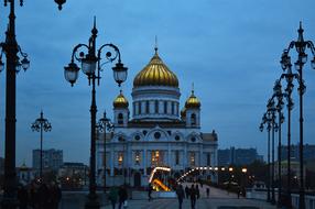 People, near the beautiful and colorful Christ The Savior Cathedral with the bridge with lights in Moscow, Russia, in the evening