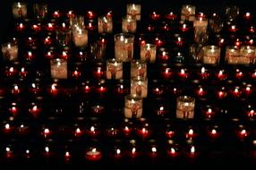 many burning candles in the dark