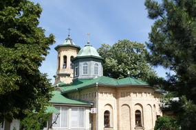 Beautiful monastery with green domes among the plants