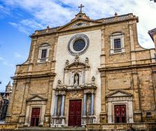 Beautiful church with the cross, at blue sky with white clouds on background, in Vic, Spain
