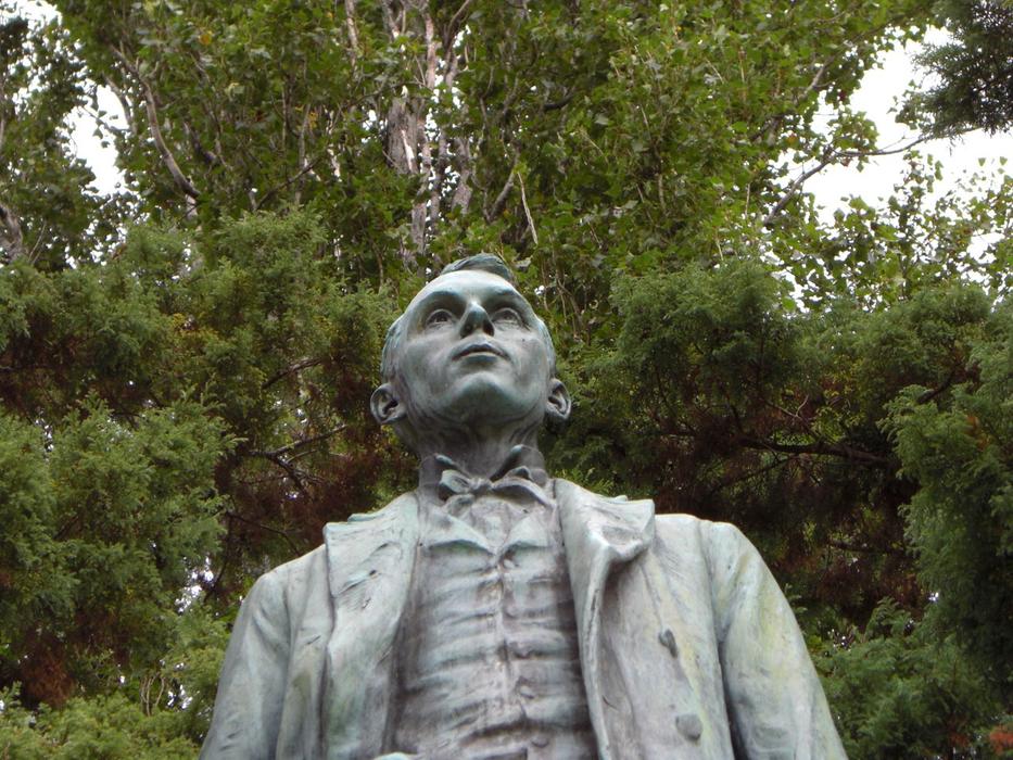 an old sculpture of a man in the park