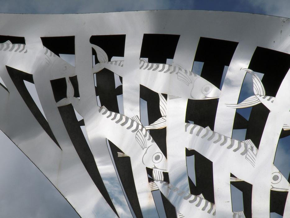 the silhouette of a fish on a white picket fence