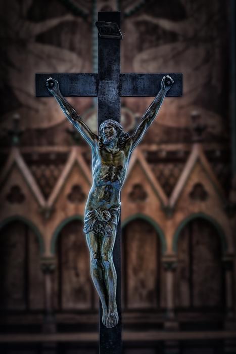 bronze Crucifixion at gothic wall