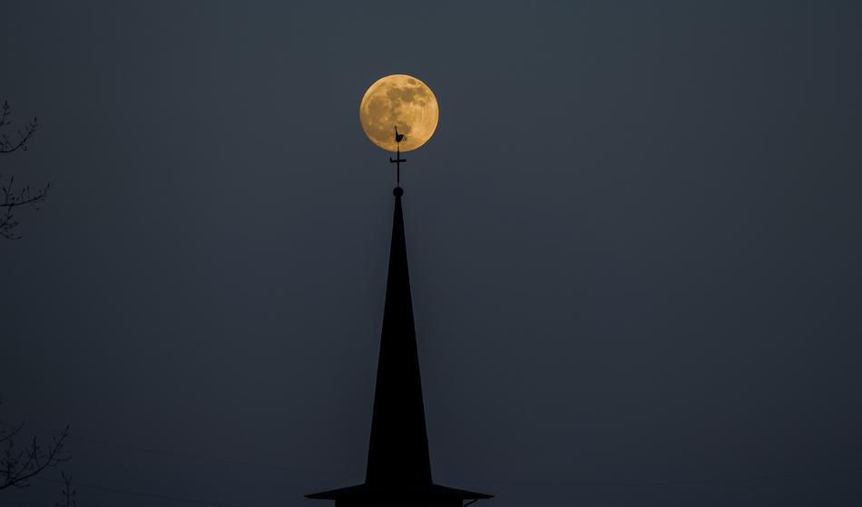 church spire on the background of the bright moon