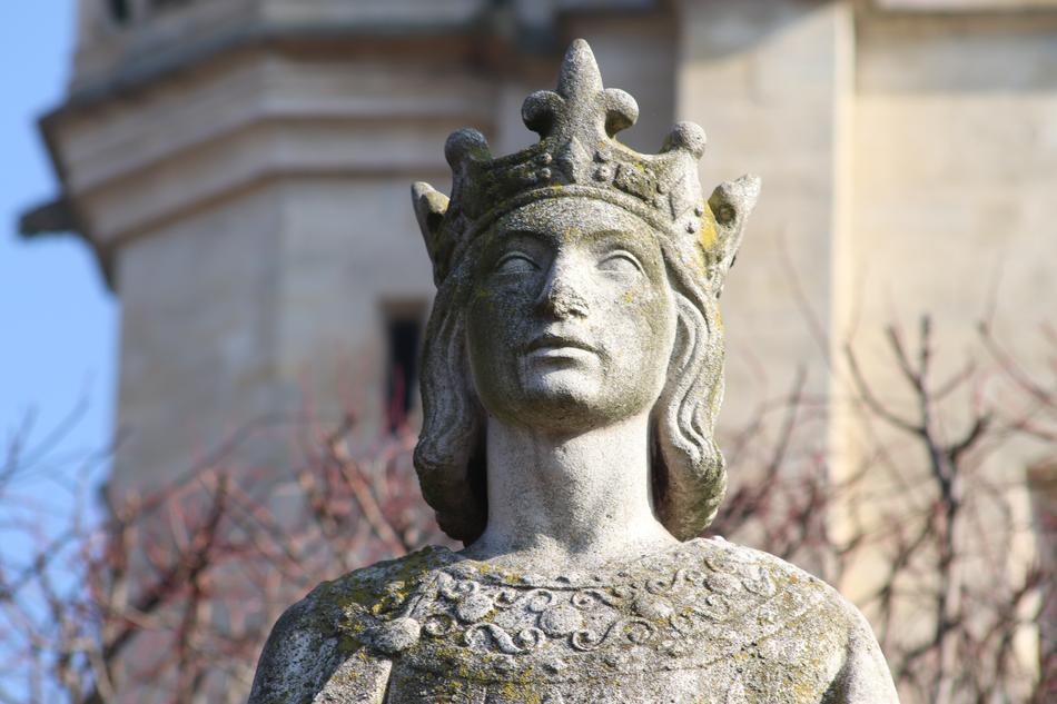 Statue of the king with the crown and background with the building and trees