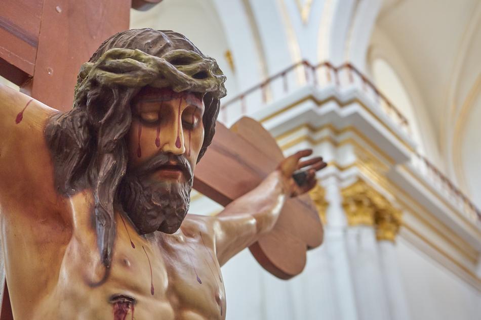 cross with a crucifix in the interior of the church close-up