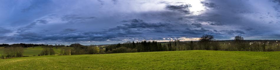 Panoramic rural view, farmland beneath stormy clouds