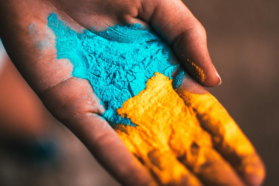 Blue, yellow and orange pain on the hand, on the Holi